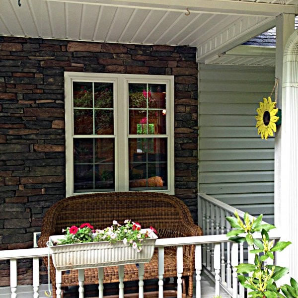 Esempio di un portico classico di medie dimensioni e davanti casa con pedane e un tetto a sbalzo