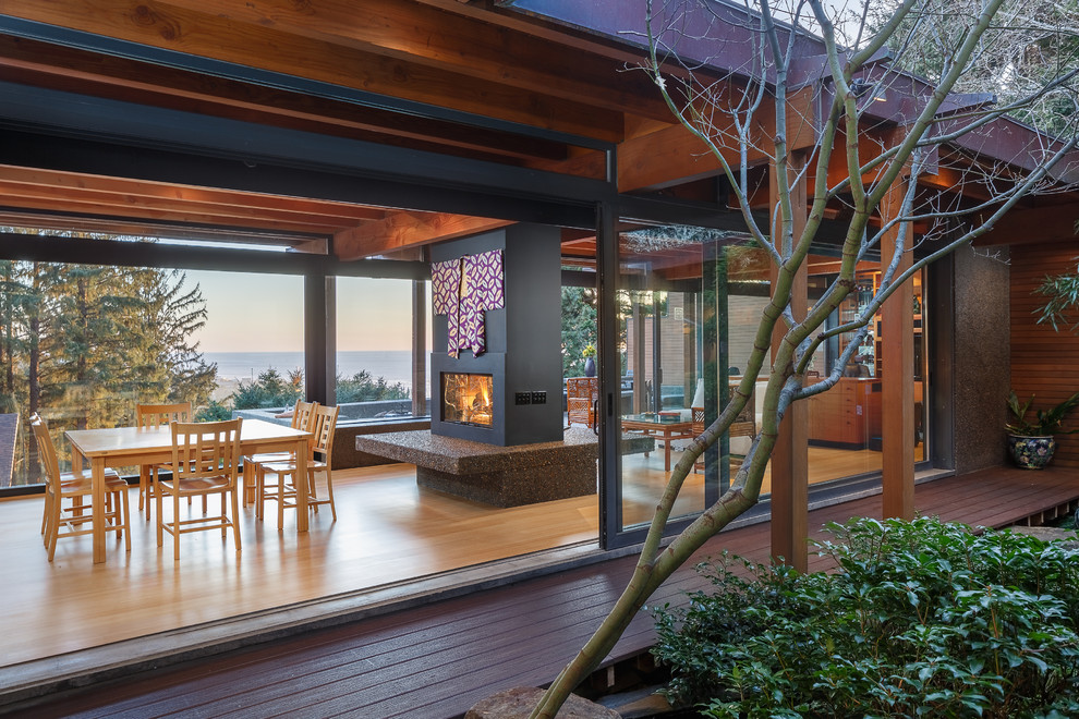 Idées déco pour un grand porche d'entrée de maison arrière asiatique avec un point d'eau, une terrasse en bois et une extension de toiture.