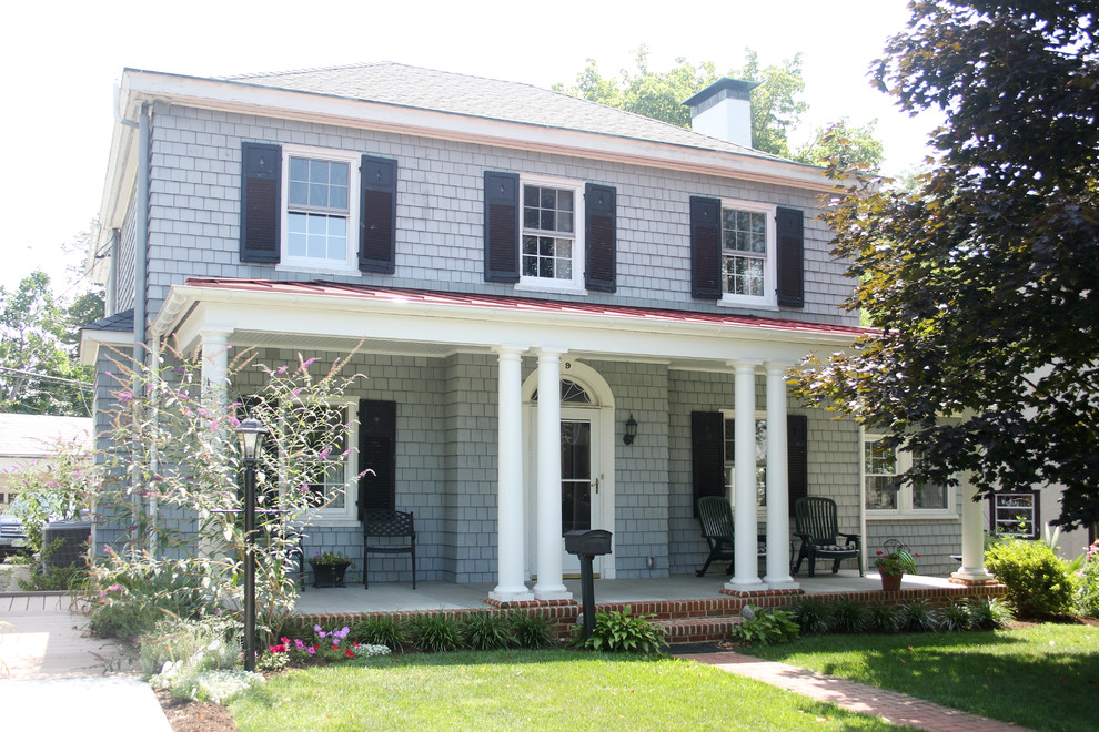 Photo of a large traditional front veranda in Baltimore with a roof extension.