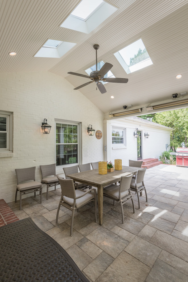 Mid-sized transitional stone back porch idea in Louisville with a fireplace and a roof extension