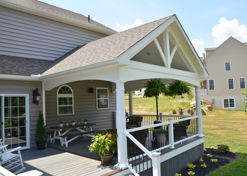 Immagine di un grande portico minimalista dietro casa con un focolare e un tetto a sbalzo