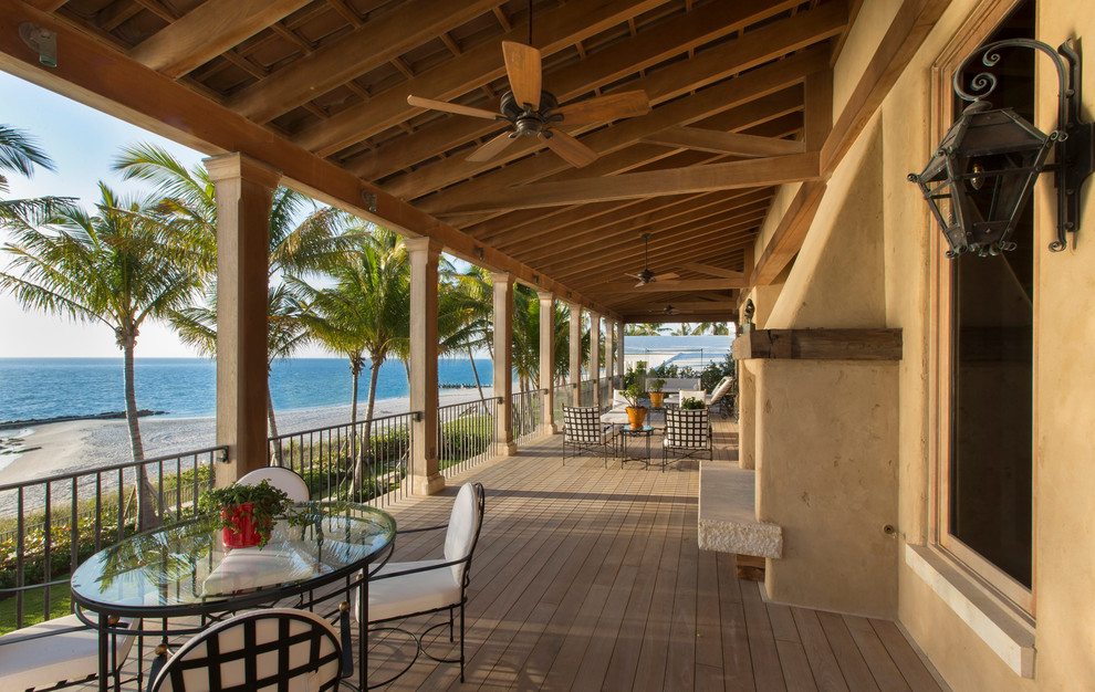 Inspiration for a mediterranean veranda in Miami with a fire feature, decking and a roof extension.