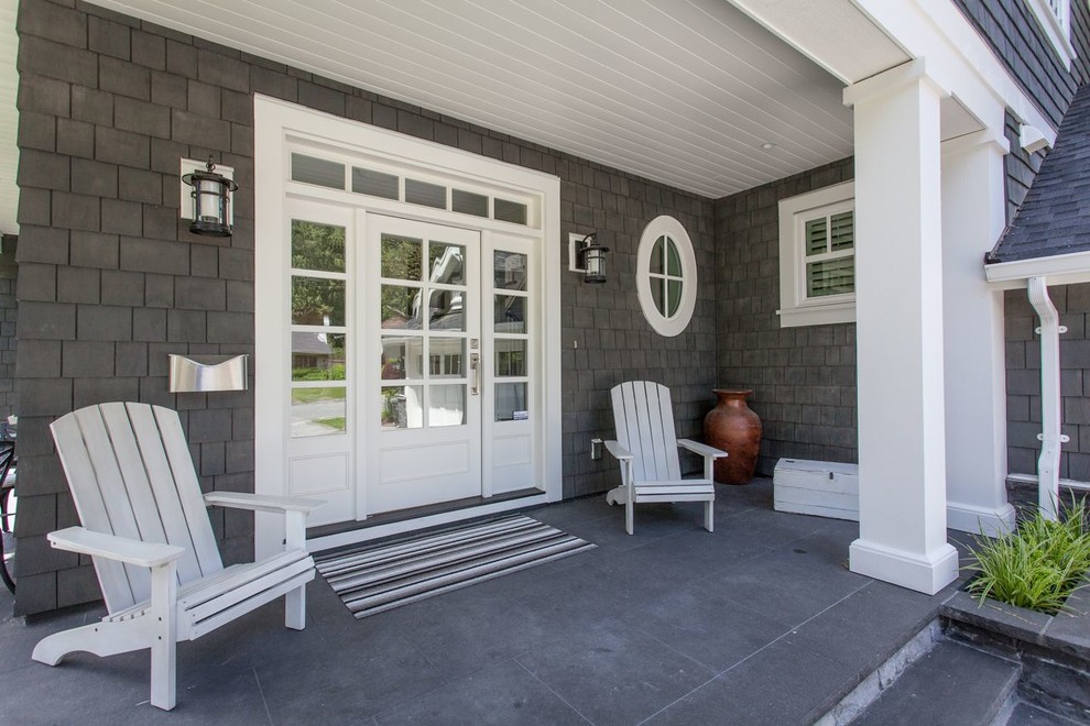Large elegant front porch photo in Vancouver with a roof extension