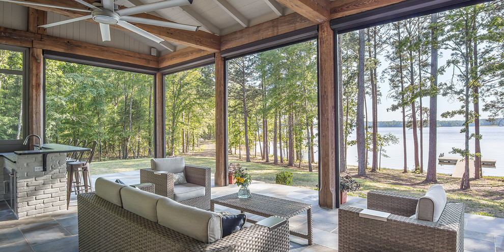 Country tile screened-in back porch idea in New Orleans with a roof extension
