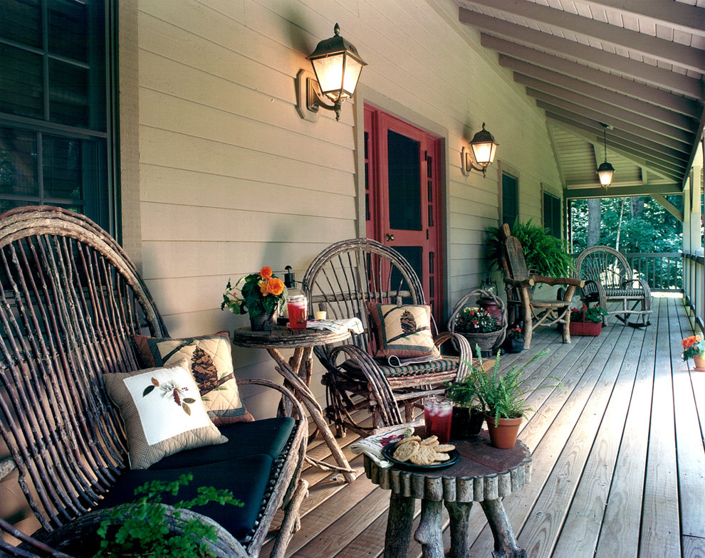 Idee per un grande portico country davanti casa con un tetto a sbalzo e pedane