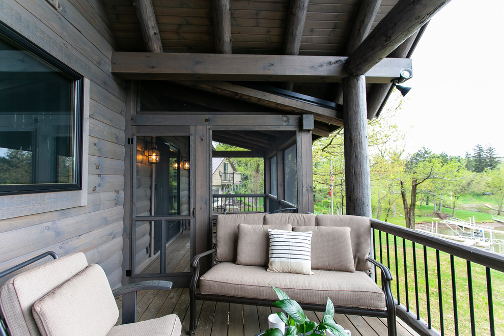 Design ideas for a large rustic front screened veranda in Columbus with decking and a roof extension.