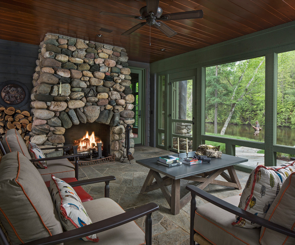 Inspiration for a rustic screened veranda in Detroit with natural stone paving and a roof extension.