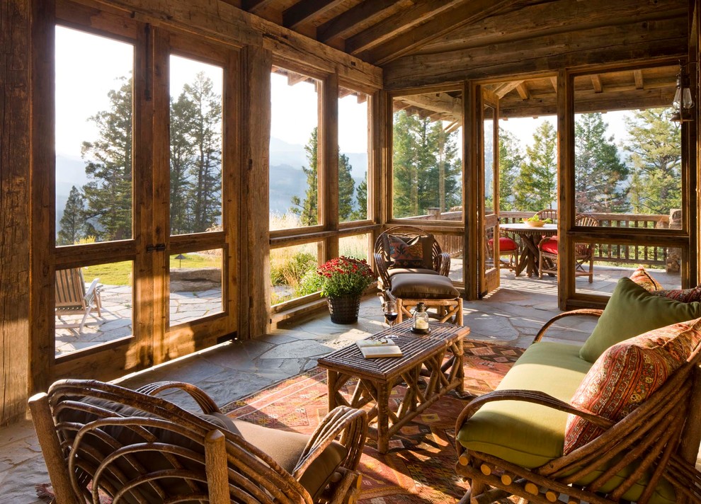 Inspiration pour un porche d'entrée de maison chalet avec des pavés en pierre naturelle, une extension de toiture, tous types de couvertures et une moustiquaire.