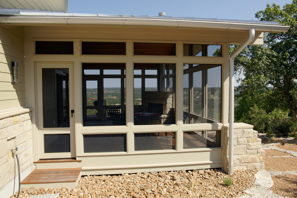 Cette image montre un grand porche d'entrée de maison latéral design avec une moustiquaire, une dalle de béton et une extension de toiture.