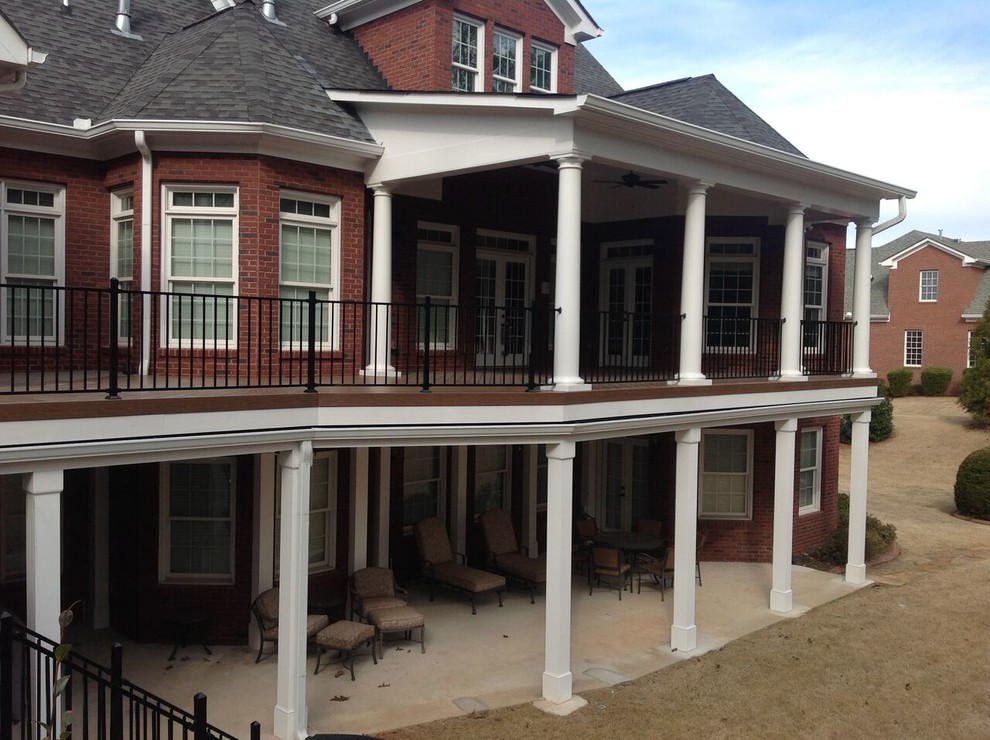 Klassisk inredning av en stor veranda på baksidan av huset, med trädäck och takförlängning