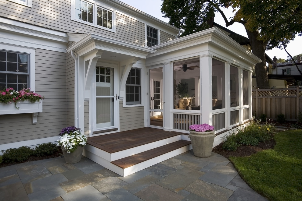 Cette photo montre un porche d'entrée de maison chic avec une terrasse en bois.