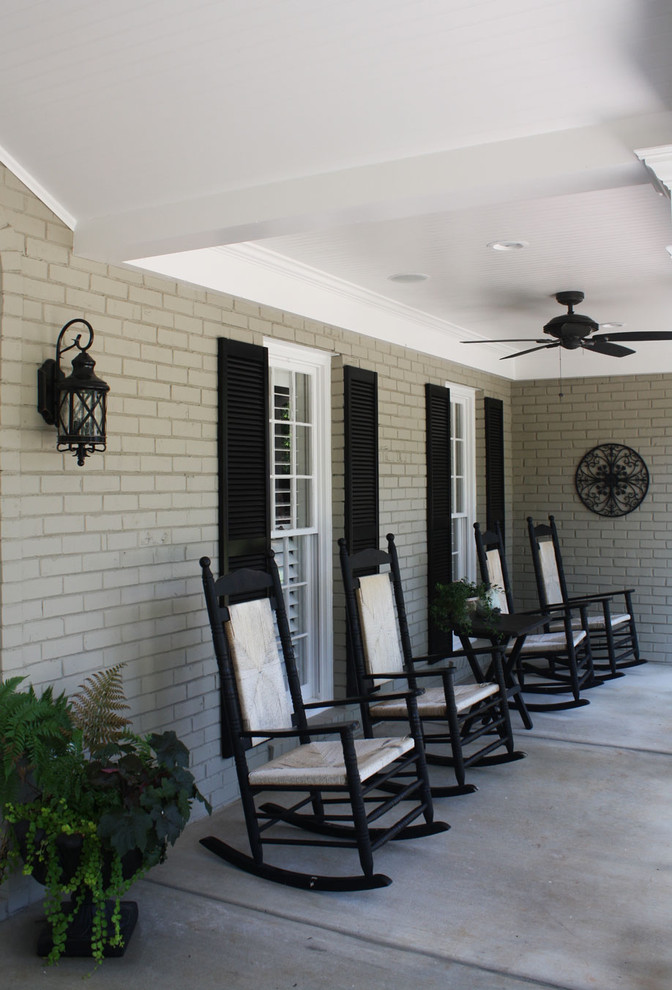 Photo of a medium sized traditional front veranda in Atlanta with a roof extension and concrete slabs.