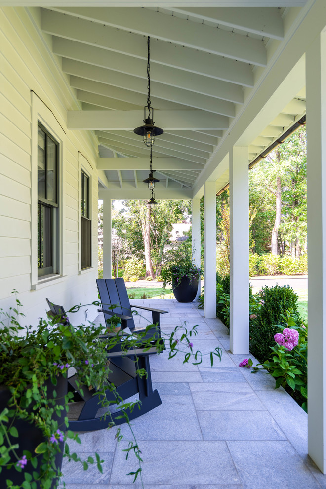 Inspiration for a farmhouse veranda in New York with tiled flooring and a roof extension.