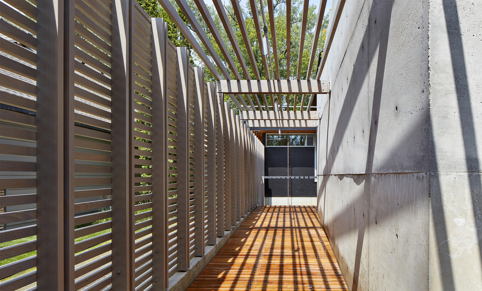 Idéer för en liten modern veranda längs med huset, med trädäck och en pergola