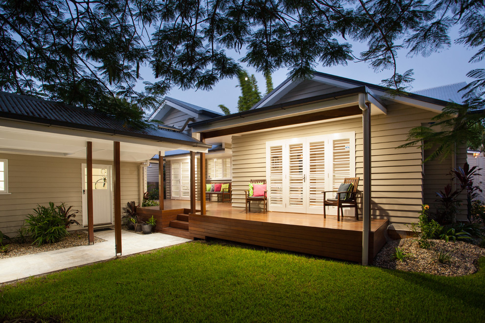 Cette image montre un petit porche d'entrée de maison avant traditionnel avec une terrasse en bois et une extension de toiture.