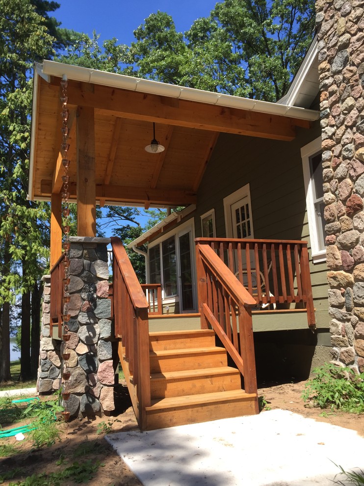 Cette photo montre un porche d'entrée de maison avant montagne de taille moyenne avec une terrasse en bois et une extension de toiture.