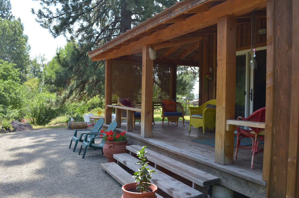 Idées déco pour un porche d'entrée de maison montagne avec une terrasse en bois et une extension de toiture.