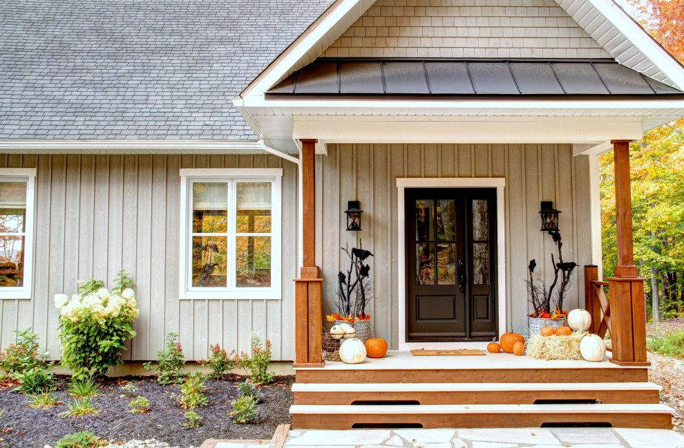 Idée de décoration pour un grand porche d'entrée de maison avant champêtre avec des colonnes et une extension de toiture.