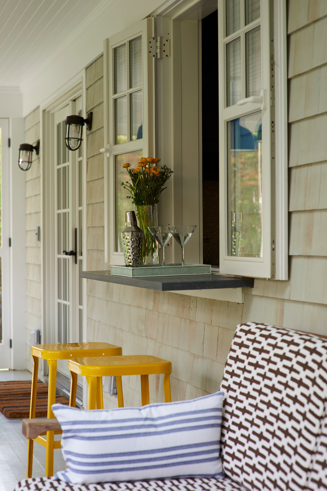 Idée de décoration pour un grand porche d'entrée de maison arrière marin avec une terrasse en bois et une extension de toiture.