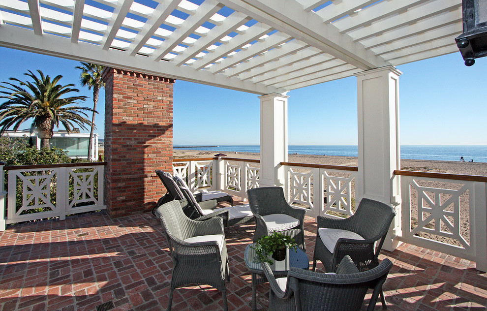 Beach style brick porch photo in Orange County with a roof extension