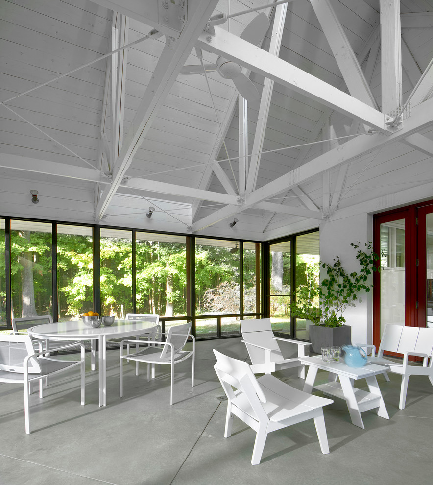 Inspiration for a small industrial concrete screened-in front porch remodel in Chicago with a roof extension
