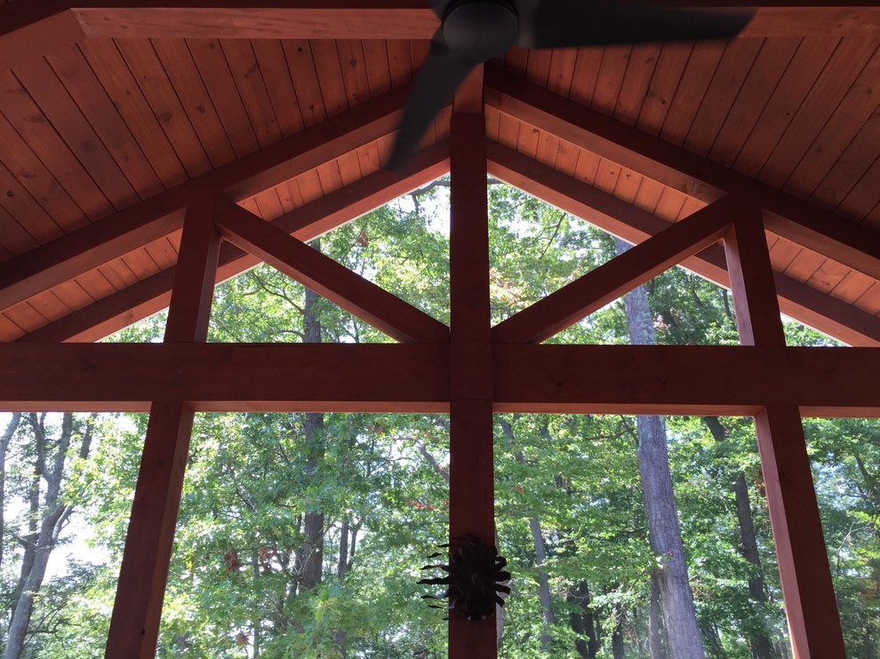 Inspiration for a large traditional back screened veranda in DC Metro with decking and a roof extension.