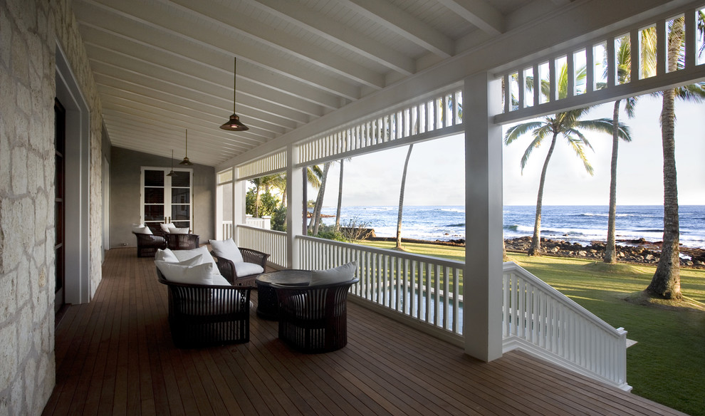 Idées déco pour un porche d'entrée de maison exotique avec une terrasse en bois et une extension de toiture.