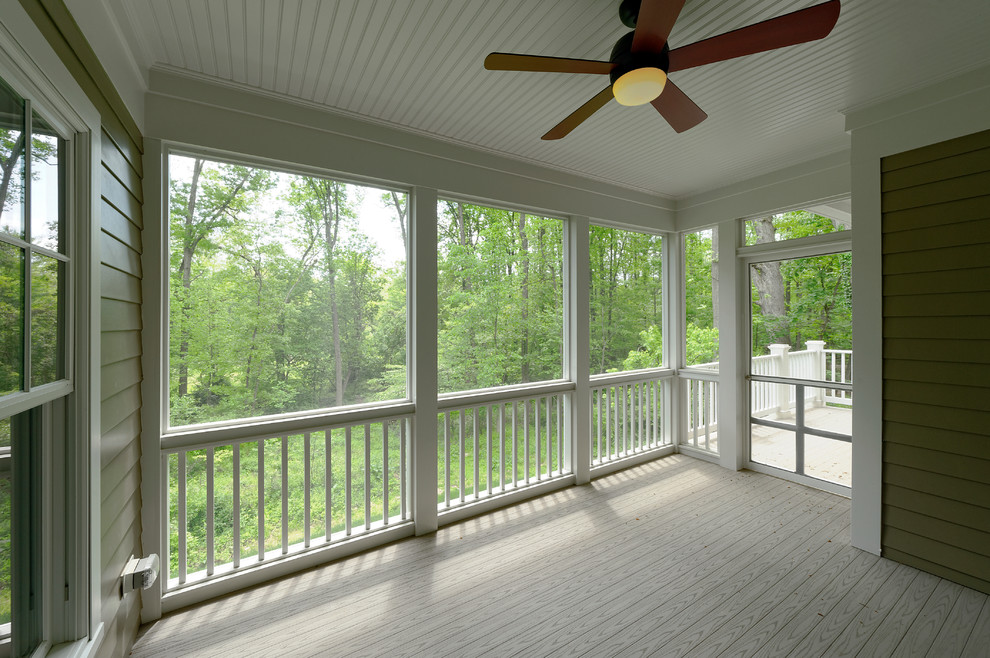 This is an example of a mid-sized craftsman screened-in back porch design in DC Metro with a roof extension and decking.