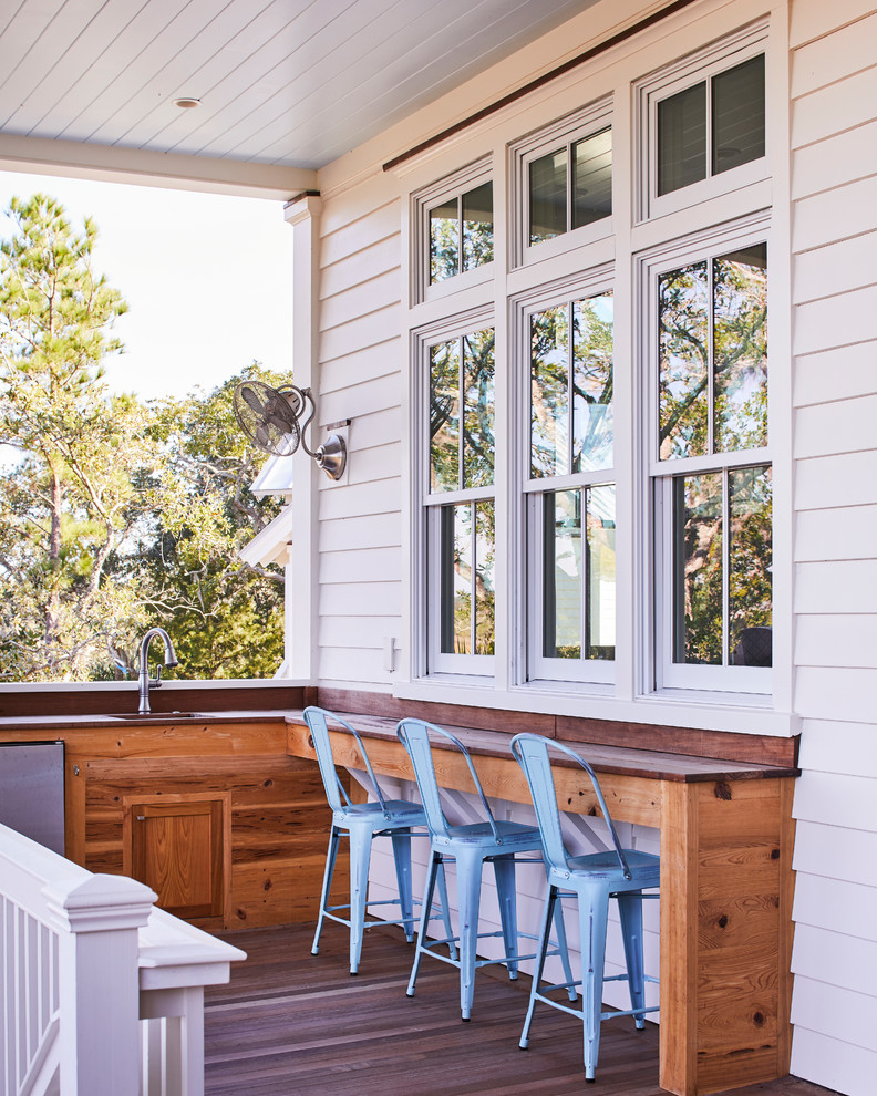 This is an example of a coastal porch design in Charleston with decking and a roof extension.