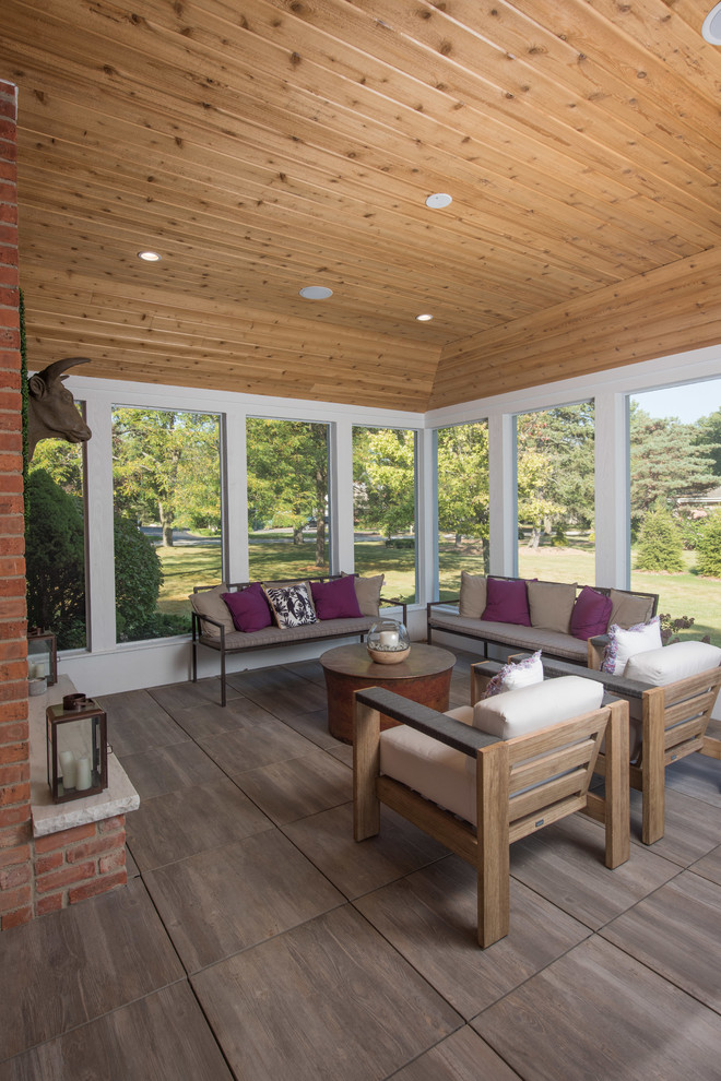 Inspiration pour un grand porche d'entrée de maison latéral traditionnel avec une moustiquaire, des pavés en pierre naturelle et une extension de toiture.