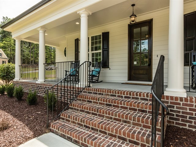 Inspiration for a transitional front porch remodel in Raleigh with a roof extension