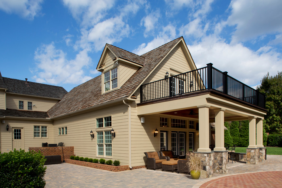 Exemple d'un grand porche d'entrée de maison arrière chic avec des pavés en pierre naturelle et une extension de toiture.
