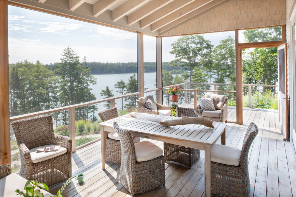 Cette photo montre un porche d'entrée de maison bord de mer avec une moustiquaire, une terrasse en bois et une extension de toiture.