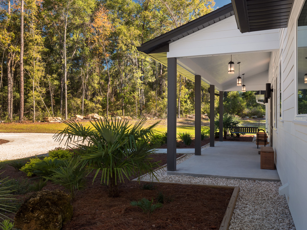 Idéer för en stor lantlig veranda längs med huset, med betongplatta och takförlängning
