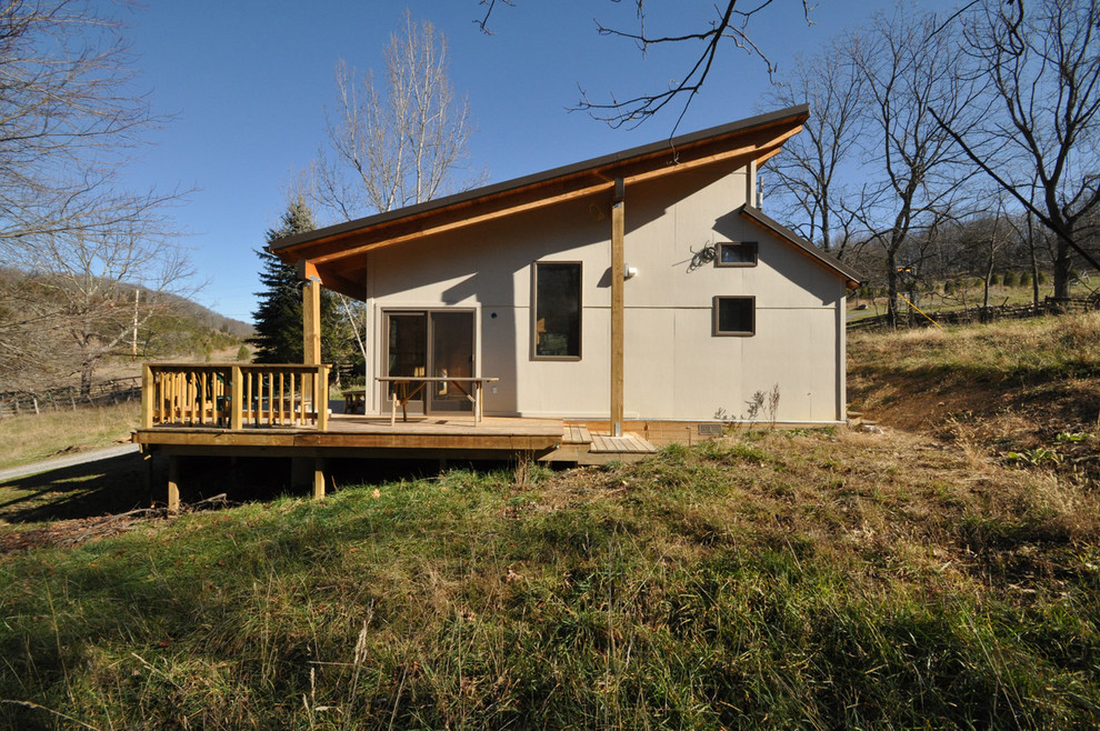 Réalisation d'un petit porche d'entrée de maison latéral design avec une terrasse en bois et une extension de toiture.