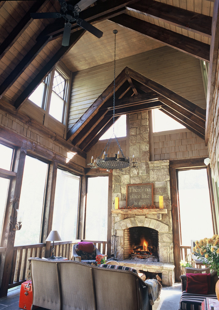 Aménagement d'un grand porche d'entrée de maison arrière classique avec une moustiquaire, des pavés en pierre naturelle et une extension de toiture.