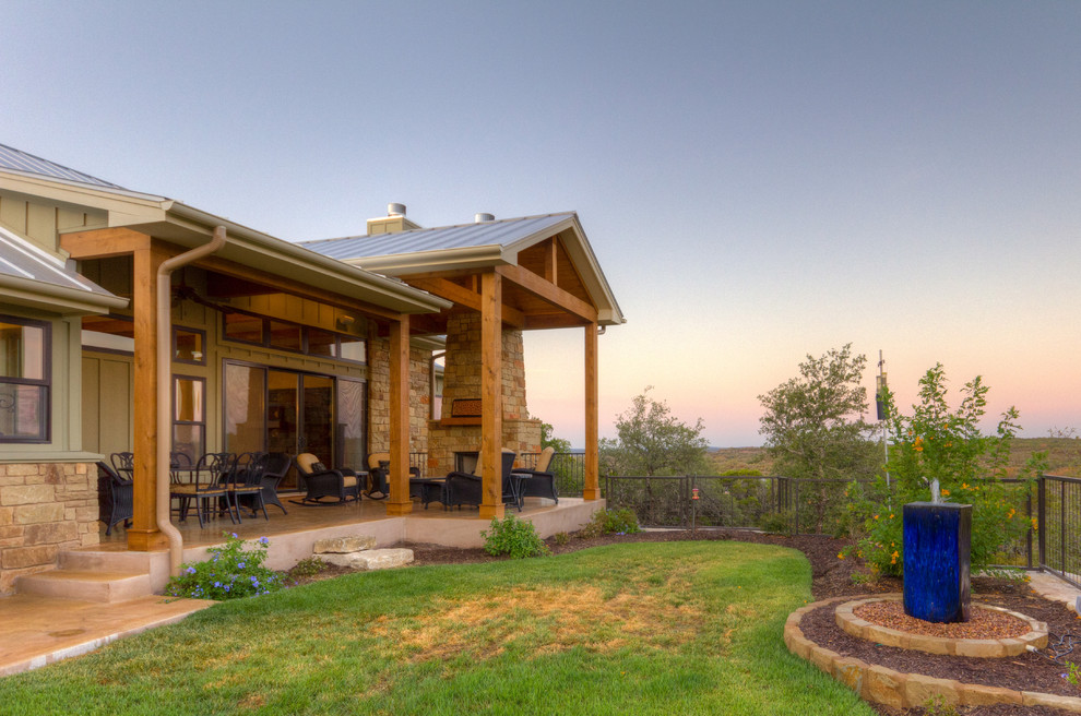 Cette photo montre un grand porche d'entrée de maison arrière craftsman avec un point d'eau, une dalle de béton et un auvent.