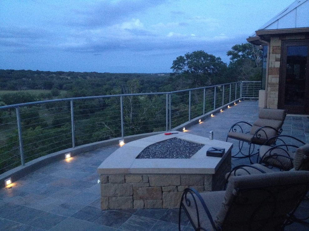 Large classic tile back porch idea in Austin with a fire pit and a roof extension