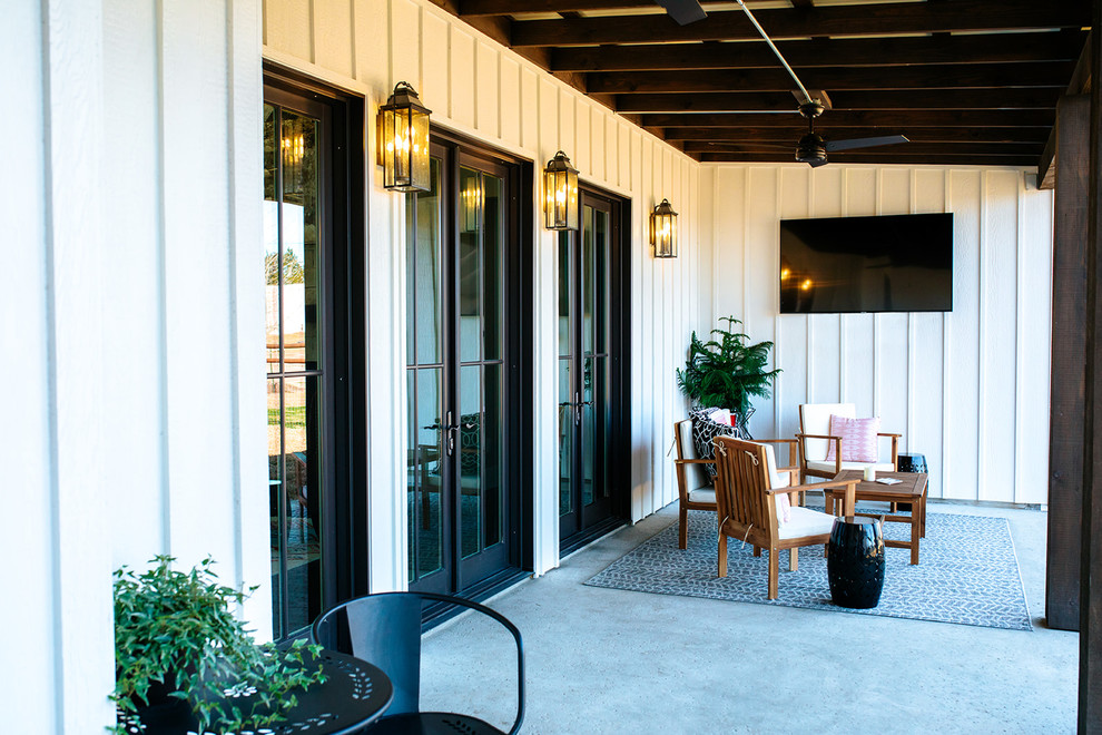 Große, Überdachte Landhausstil Veranda hinter dem Haus mit Outdoor-Küche und Betonplatten in Austin