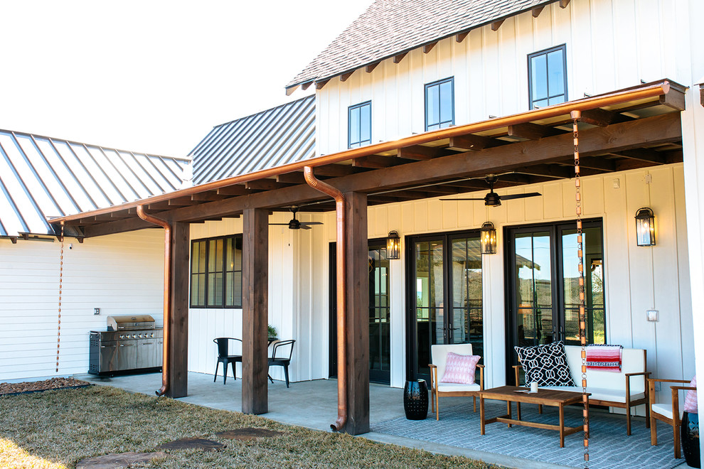 Inspiration pour un porche d'entrée de maison arrière rustique de taille moyenne avec une cuisine d'été, une dalle de béton et un auvent.