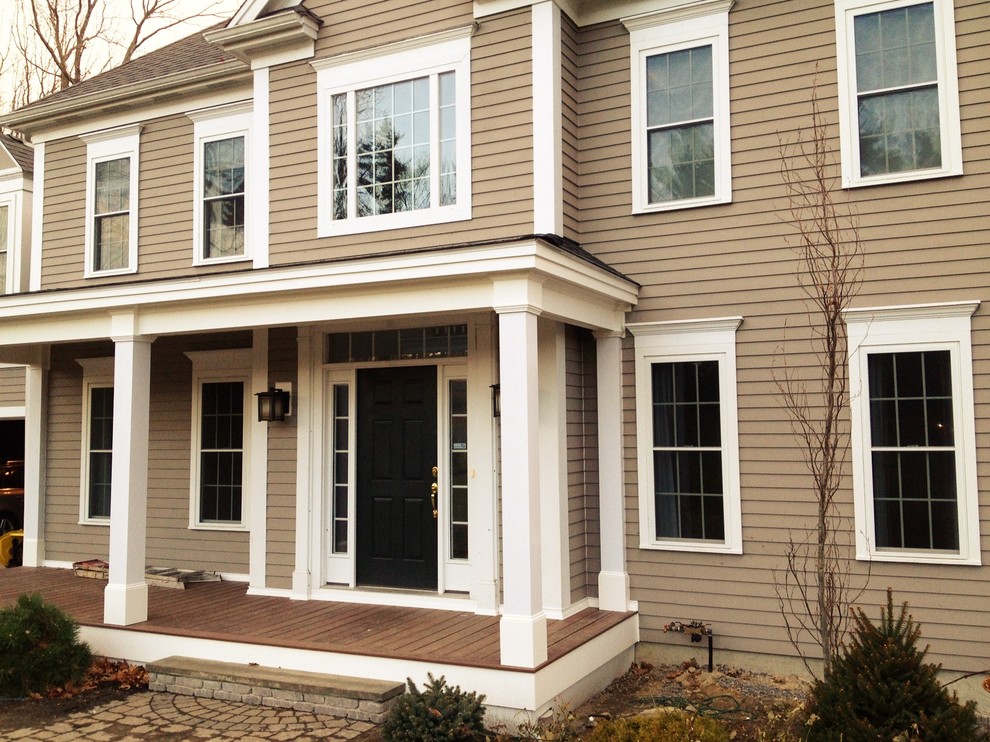 This is an example of a mid-sized cottage front porch design in Boston with decking and a roof extension.