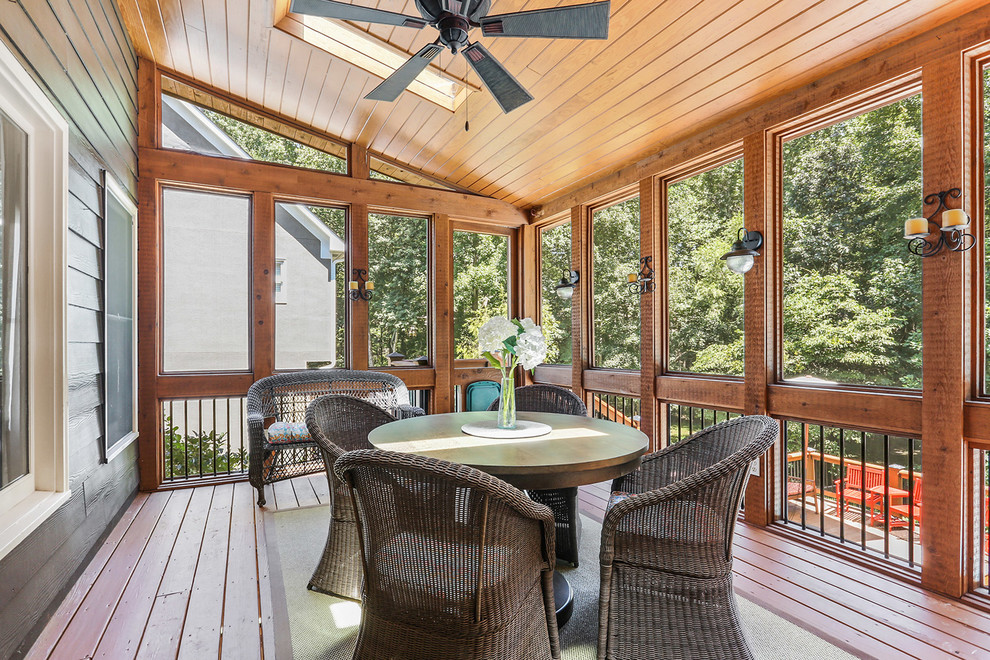 This is an example of a rustic screened-in back porch design in Atlanta with decking and a roof extension.