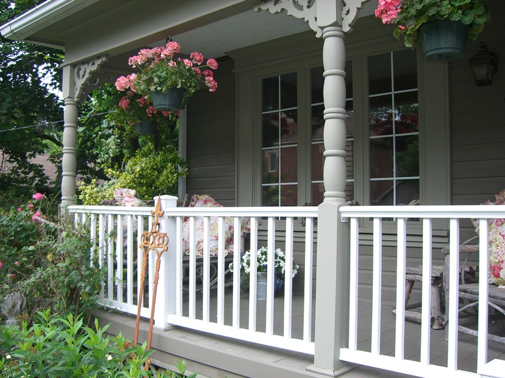 Immagine di un portico stile shabby di medie dimensioni e davanti casa con pedane e un tetto a sbalzo
