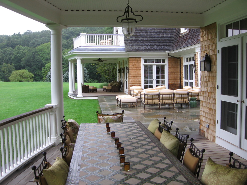 Esempio di un ampio portico classico dietro casa con pavimentazioni in pietra naturale e un tetto a sbalzo