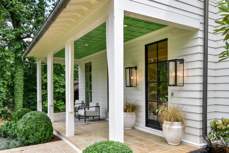 Mittelgroße, Überdachte Landhaus Veranda hinter dem Haus mit Natursteinplatten in New Orleans