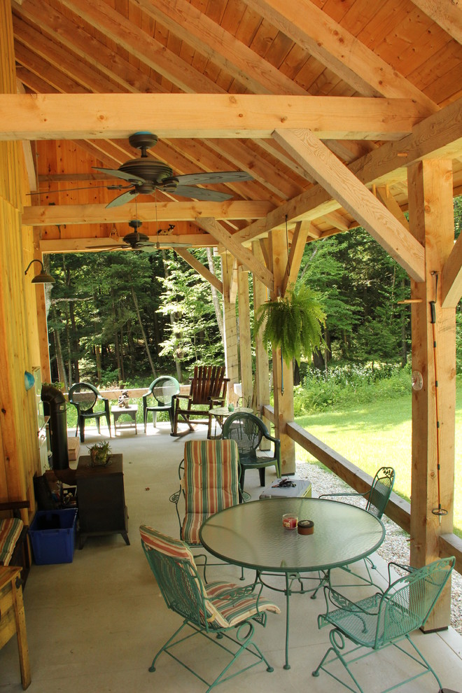 Cette image montre un porche d'entrée de maison chalet avec une dalle de béton et une extension de toiture.