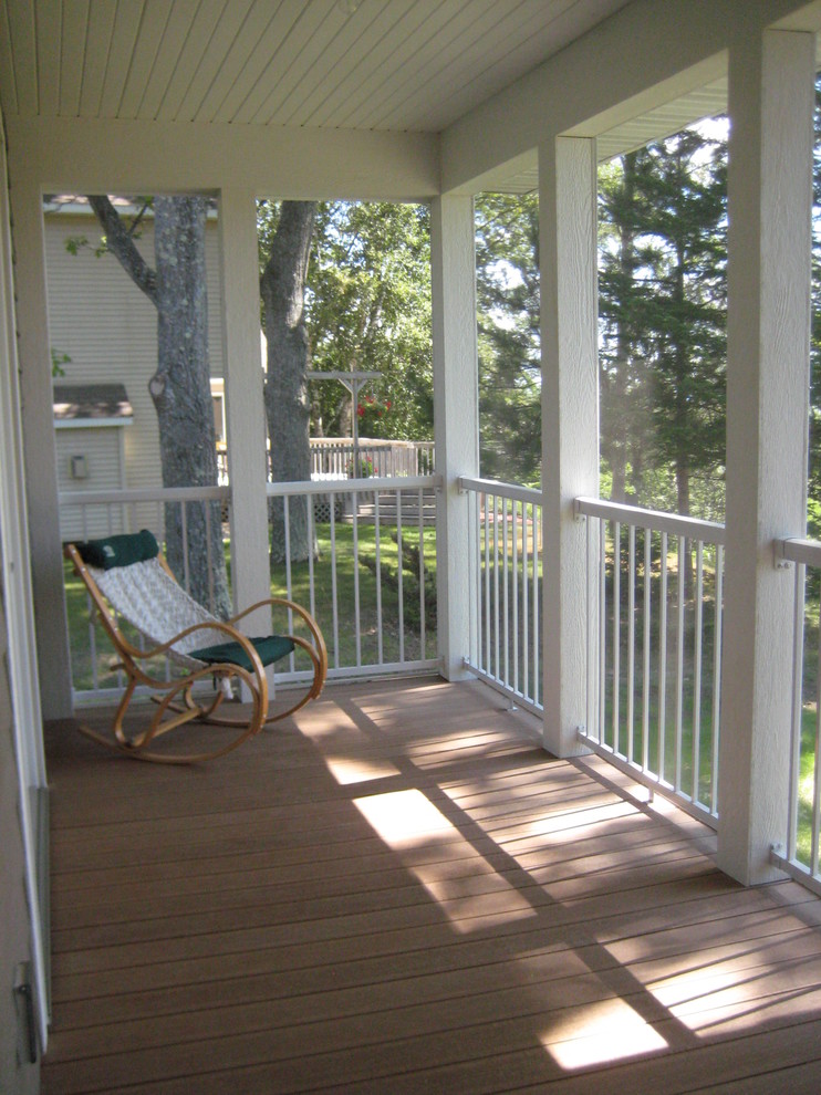 Idées déco pour un porche d'entrée de maison avant craftsman de taille moyenne avec une moustiquaire, une terrasse en bois et une extension de toiture.