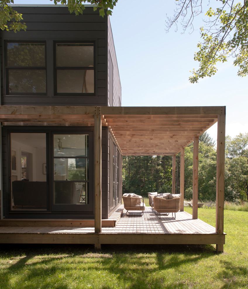 Idée de décoration pour un porche d'entrée de maison arrière design de taille moyenne avec une terrasse en bois.