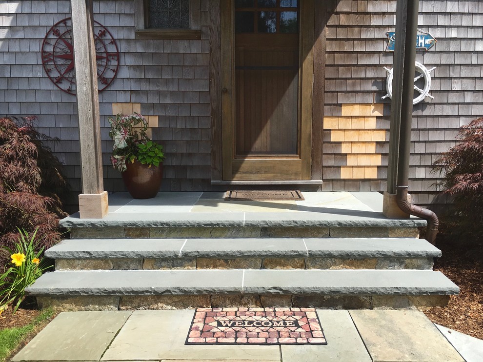 Inspiration pour un très grand porche d'entrée de maison avant marin avec des pavés en pierre naturelle et une extension de toiture.
