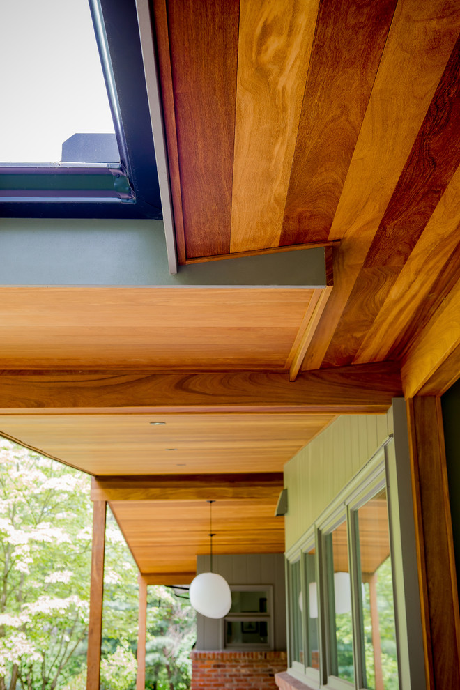 Exemple d'un porche d'entrée de maison avant rétro de taille moyenne avec du béton estampé et une extension de toiture.